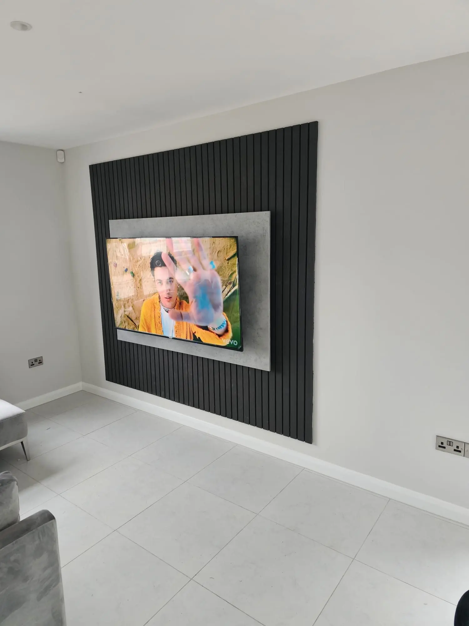 Fitted media wall with black slatted panelling and recessed TV
