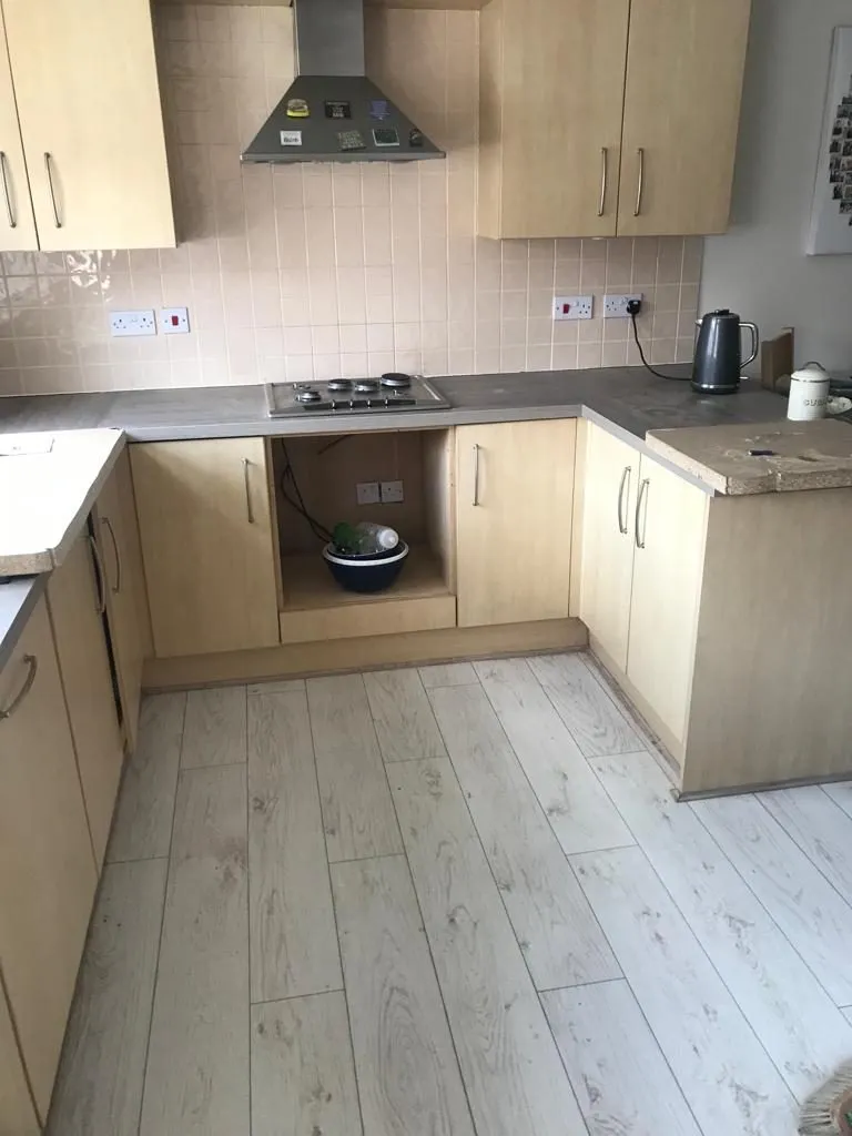 Cream kitchen with contrasting worktops and wood-effect flooring