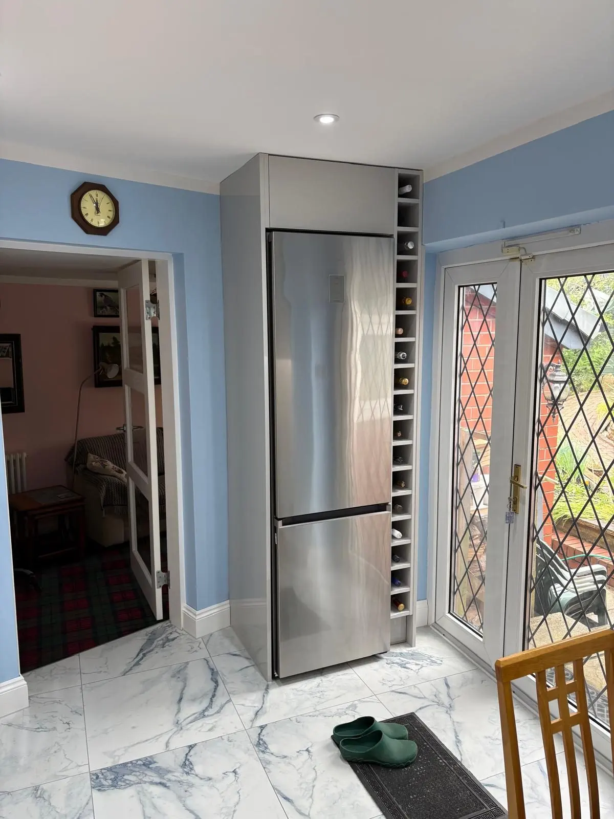 Integrated fridge-freezer housing with built-in wine rack beside French doors