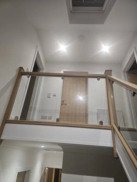 Oak and glass landing balustrade looking down the renovated staircase
