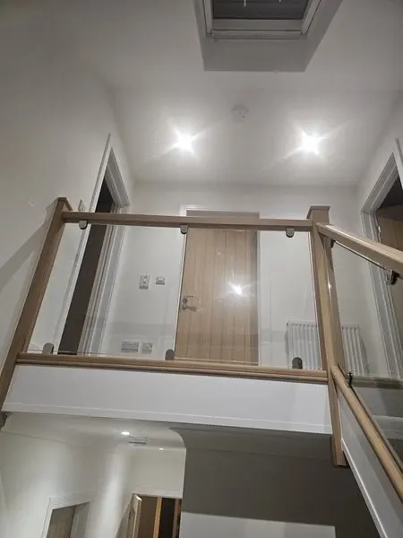 Oak and glass landing balustrade looking down the renovated staircase